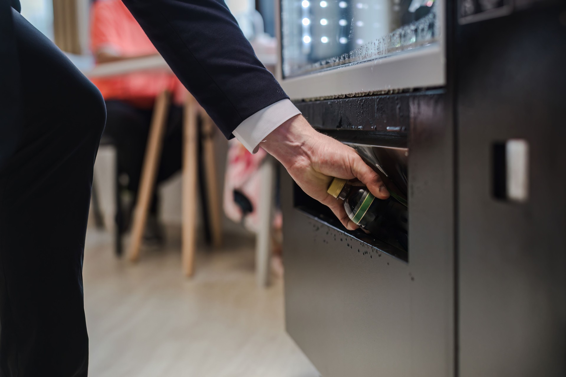 hand pushing button on vending machine operation panel. Hand man use of soft drink vending system. Technology and consumption concept. People choosing a snack or drink at vending machine